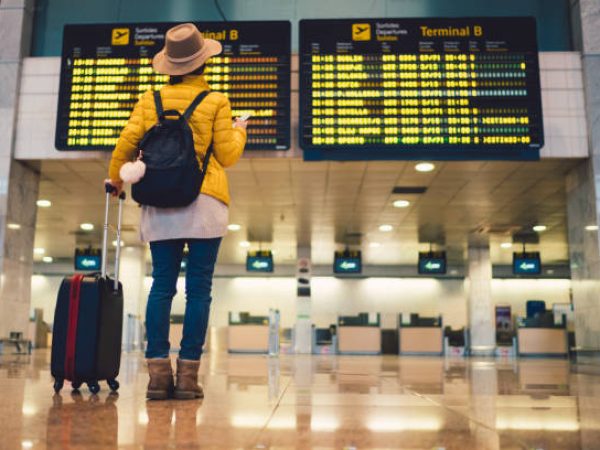 Young woman at the airport in Barcelona checking for the flight schedule